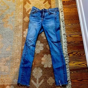 These are skinny blue jeans frayed at the bottom.